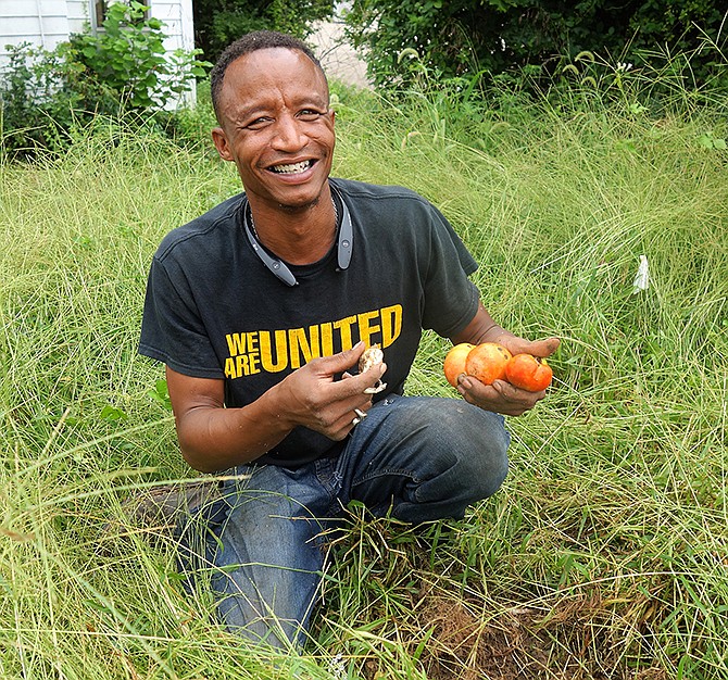Freddie Thompson of Fulton shows off some of the vegetables grown in the community garden Monday. He uses the garden as a tool for mentoring local youth.