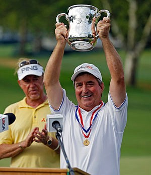 Gene Sauers raises the trophy Monday after winning the U.S. Senior Golf Open at the Scioto Country Club in Upper Arlington, Ohio.