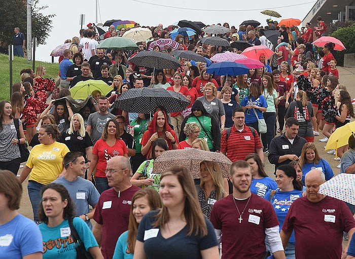 Teachers and staff from Jefferson City Public Schools follow the band to the football field for a JCPS employee group photograph. The public school syste hosted a pep rally Monday morning at Jefferson City High School that started with a donut and coffee reception followed by several speakers, the group photo and workshops. 