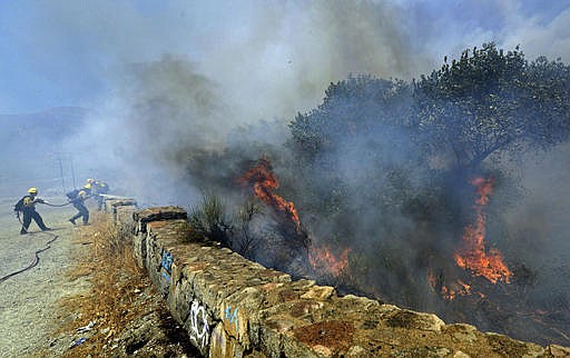 Firefighters battle a wildfire along Cajon Boulevard in the Cajon Pass north of Devore, Calif., Tuesday, Aug. 16, 2016. The fire erupted before noon and authorities said it had swelled to over 2,000 acres by early afternoon. Evacuations have been ordered. (Will Lester/The Sun, Southern California News Group via AP)