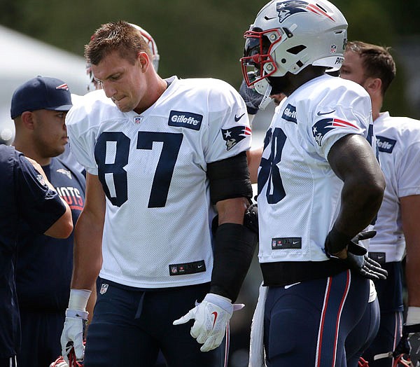 Patriots tight end Rob Gronkowski (left) holds his helmet while standing next to teammate tight end Martellus Bennett during Monday's training camp practice with the Bears in Foxborough, Mass.