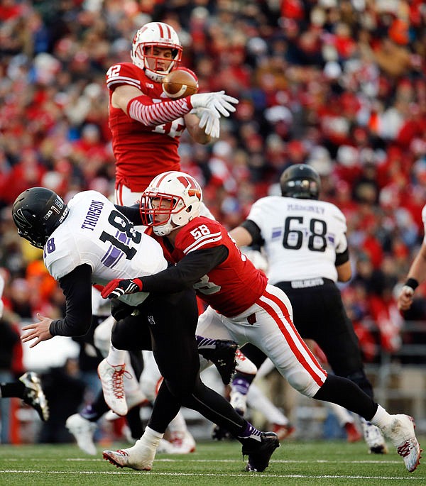 In this Nov. 21 file photo, Wisconsin's T.J. Watt (top) knocks down a pass thrown by Northwestern quarterback Clayton Thorson (left) during the first half of a game in Madison, Wis.