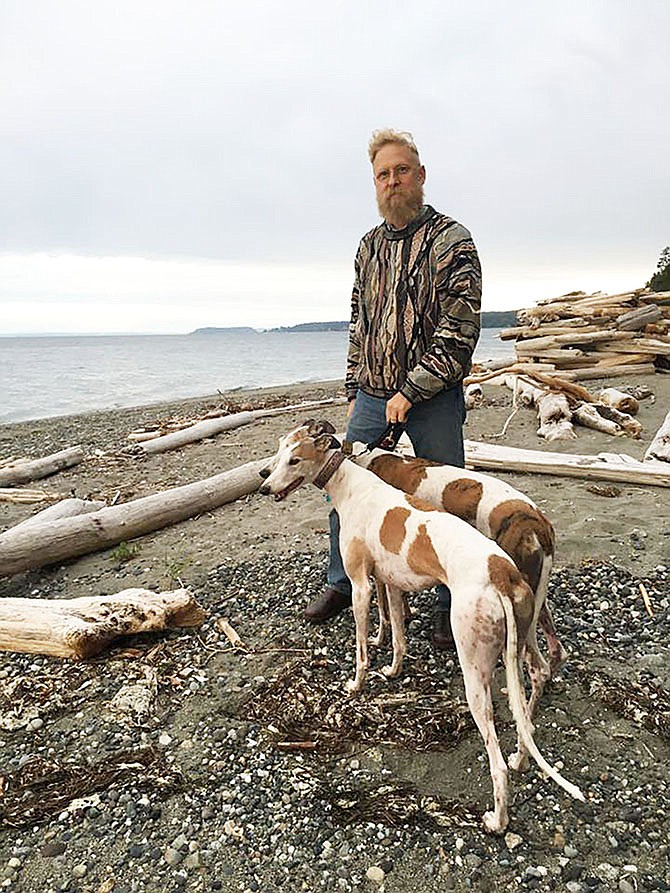 Artist Brian Mahieu, formerly of Fulton, walks his greyhounds at Whidbey Island in Washington state.