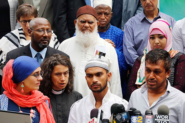Saif Akonjee, front row third from left, son of slain Imam Maulana Alauddin Akonjee, joins with representatives of Islamic groups and leaders of the interfaith community for a news conference Thursday at City Hall in New York. The imam and Thara Uddin were gunned down Saturday after leaving a mosque in Queens. Oscar Morel has been charged in the murders. 