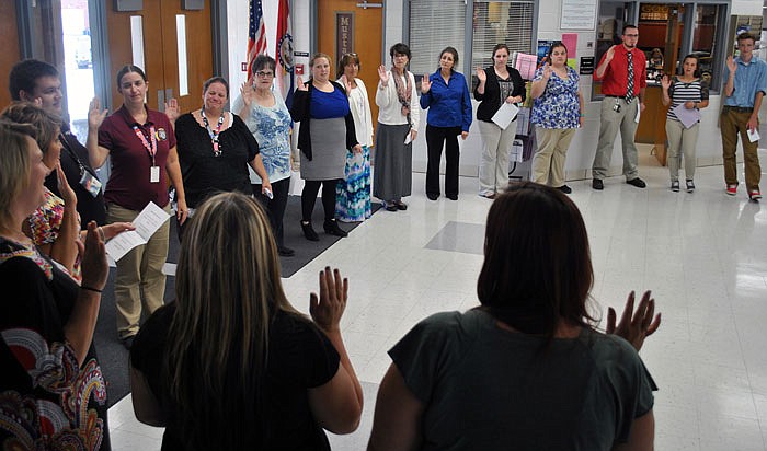 Thirty new PAVE AmeriCorps members stand in a "circle of friends" with guests and take their Oath of Service during a ceremony Wednesday at Eldon High School.