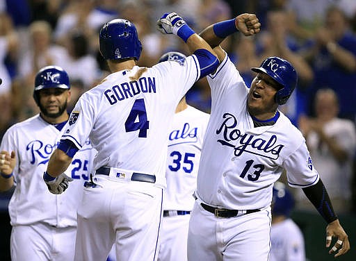 Kansas City Royals' Alex Gordon (4) is congratulated by teammate Salvador Perez (13) after hitting a grand slam off Minnesota Twins starting pitcher Tyler Duffey during the fourth inning of a baseball game at Kauffman Stadium in Kansas City, Mo., Thursday, Aug. 18, 2016.