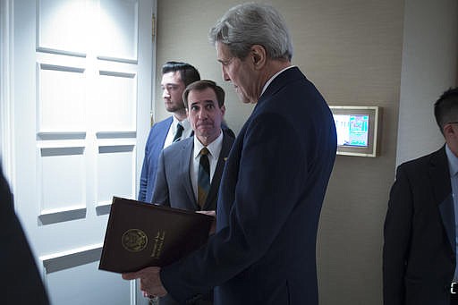 In this Oct. 23, 2015 file-pool photo, Secretary of State John Kerry, speaks to senior adviser John Kirby before a news conference in Vienna. The State Department says a $400 million cash payment to Iran was contingent on the release of American prisoners. Spokesman Kirby says negotiations over the U.S. returning Iranian money from a decades-old account was conducted separately from the prisoner talks. But he says the U.S. withheld delivery of the cash as leverage until the U.S. citizens had left Iran.
