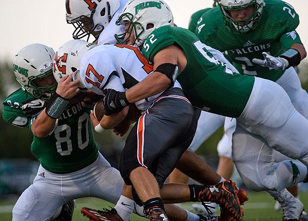 Blair Oaks defenders Garrett Welschmeyer (top), Ben Thomas (left), and Drew Boessen (right) swarm Kirksville running back Blake Lewis and record the stop behind the line of scrimmage during Friday night's season opener at the Falcon Athletic Complex in Wardsville.