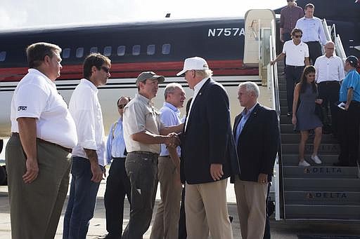 Republican presidential candidate Donald Trump, followed by his running mate, Indiana Gov. Mike Pence, shakes hands with Louisiana Attorney General Jeff Landry as he is greeted by Louisiana officials upon his arrival at the Baton Rouge airport in Baton Rouge, La., Friday, Aug. 19, 2016. 