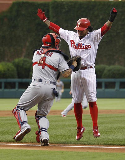 Philadelphia Phillies' Freddy Galvis, right, is tagged out by St. Louis Cardinals catcher Yadier Molina (4) on a rundown between third base and home in the first inning of a baseball game, Friday, Aug. 19, 2016, in Philadelphia.