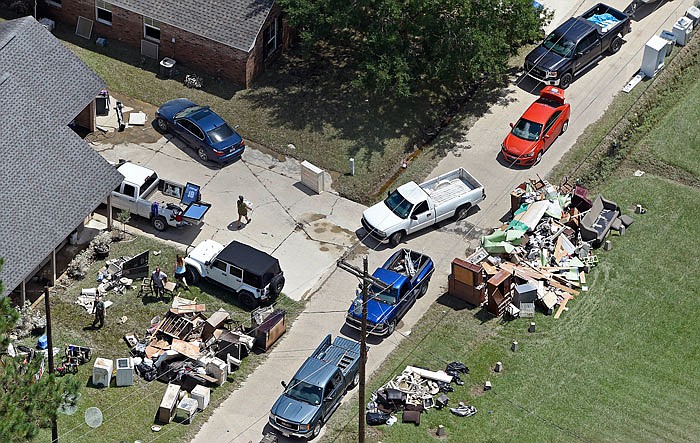 Residents gather house debris for the trash near Highway 16 Tuesday in Denham Springs, Louisiana, as people begin the recovery process from the severe weather flooding in Livingston Parish, east of Baton Rouge, Louisiana.