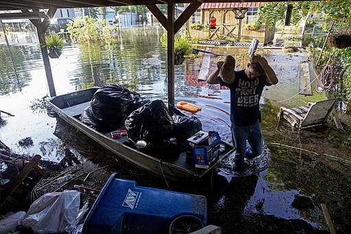 Daniel Stover, 17, wipes his head as he helps Laura Albritton, rescue personal belongings in Sorrento, La., Saturday, Aug. 20, 2016. Louisiana continues to dig itself out from devastating floods, with search parties going door to door looking for survivors or bodies trapped by flooding.