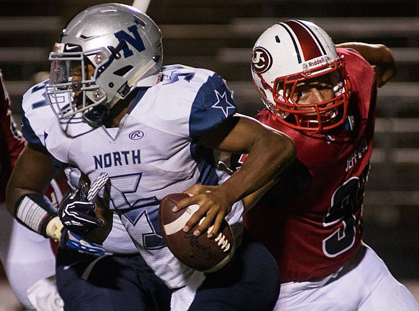 Jefferson City lineman Nik Williams flushes McCluer North quarterback Rashad Wilkins out of the pocket during Friday night's season opener at Adkins Stadium.