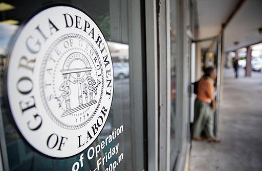 In this Friday, Sept. 19, 2014, file photo, a worker leaves a Georgia Department of Labor career center, in Atlanta. 