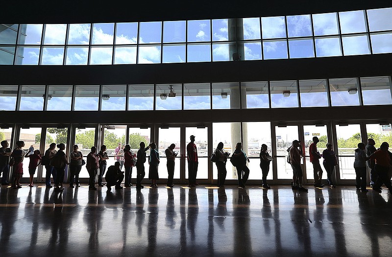 In this Monday, March 31, 2014 file photo, people line up to enroll for health insurance at the Alamodome in San Antonio, Texas, hours before the deadline in the first enrollment period of the Affordable Care Act.