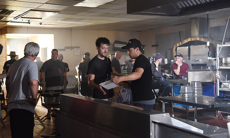 In this August 2016 photo, Mark Reichard, middle left, and Jay Shipman, right, both Jefferson City natives, work on a scene of a new Andrew P. Jones movie shot in Jefferson City. He brought cast and crew to the city to shoot the movie "Darkness Reigns," using the closed Truman Hotel as the movie's set.