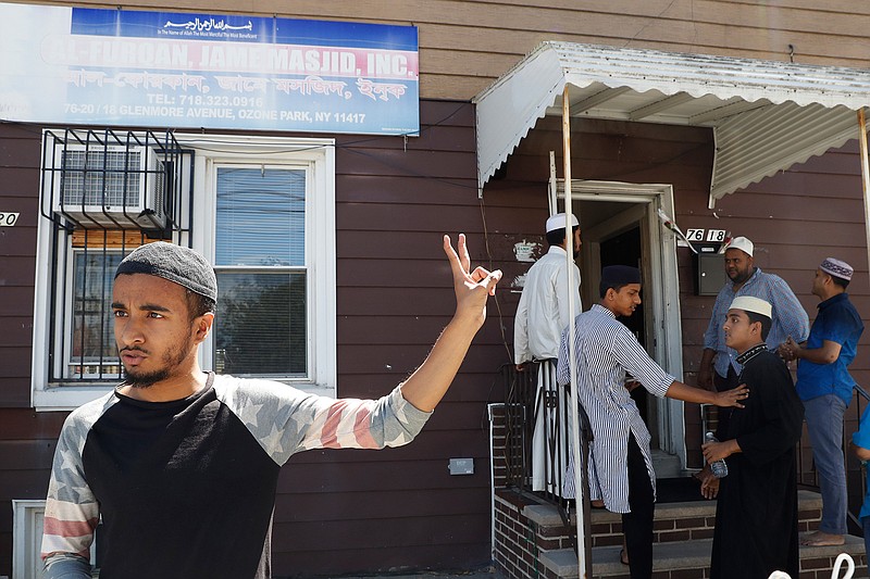 In this Wednesday, Aug. 17, 2016, photo Ashik Uddin gestures as he speaks during an interview with The Associated Press outside the Al-Furqan Jame mosque in the Ozone Park neighborhood of the Queens borough of New York.  The shooting of an imam and his assistant near their New York mosque has unnerved Muslim residents of the Ozone Park section of Queens. 