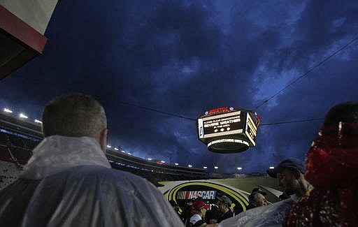 People look at the threatening sky as stormy weather delays the start of the NASCAR Sprint Cup Series auto race, Saturday, Aug. 20, 2016, in Bristol, Tenn. Racing eventually was suspended to resume Sunday.