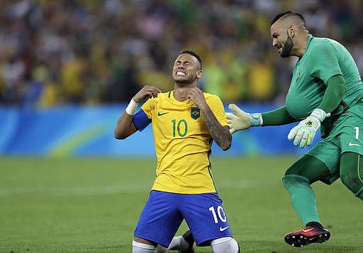 Brazil's Neymar cries as he kneels down to celebrate with teammate goalkeeper Weverton after scoring the decisive penalty kick during the final match of the men's Olympic football tournament between Brazil and Germany at the Maracana stadium in Rio de Janeiro, Brazil, Saturday Aug. 20, 2016. Brazil won the gold medal on a penalty shootout.