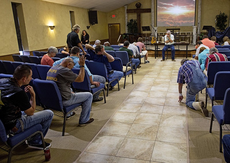 Members of the South Walker Baptist Church led by pastor Mark Carroll, center, pray at the conclusion of what is normally a time for Bible study, but which became an informal talk about experiences during the flood in Walker, La., Sunday, Aug. 21, 2016. The church was an island of high ground in a community flooded with 4-5 feet of water a week earlier. During and since the flood the church is serving as a shelter and food distribution point for the community.