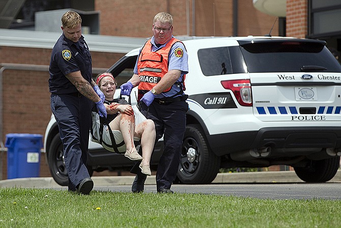 Emergency personnel carry a volunteer with simulated injuries during a training exercise for an active shooter at Hopewell Elementary School in West Chester, Ohio. Violent or disruptive threats are increasing nationwide, according to police, school employees, security consultants and others.