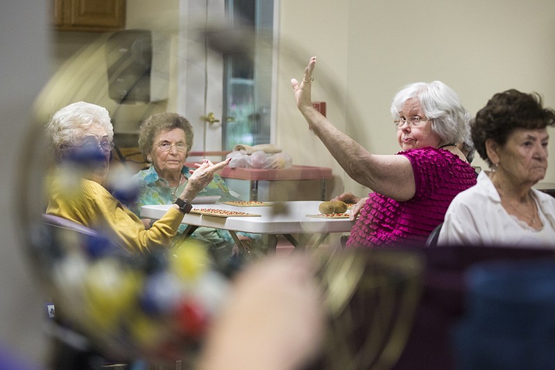 Kathy Freudiger raises her hand Monday to announce she got "Bingo" at Cowhorn Creek Estates in Texarkana, Texas. Theracare Home Care, which has an office in Cowhorn Creek Estates, provides care and hosts activities.
