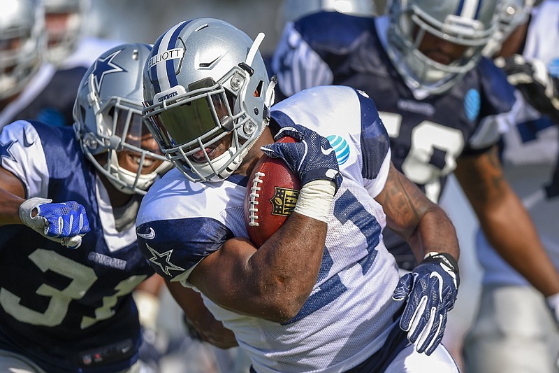 Dallas Cowboys running back Ezekiel Elliott avoids the defense as he rushes the ball during practice Tuesday in Oxnard, Calif.
