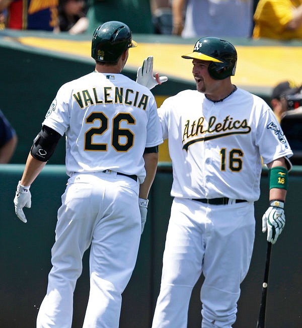 In this May 28 file photo, Athletics third baseman Danny Valencia is congratulated by Billy Butler after hitting a home run off Tigers pitcher Matt Boyd in Oakland, Calif.
