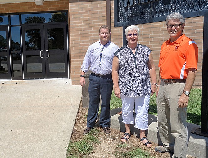 From left, Principal Jeremy Davidson, Brenda Maddox and David Tramel stand outside the new front doors in front of New Bloomfield High School Monday afternoon.