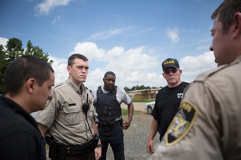 Little River County Sheriff's deputies and others make a plan before continuing the search for Christopher Whistle on Tuesday, Aug. 23, 2016 north of Ashdown, Ark. Christopher Whistle, of Texarkana, Ark., evaded police and fled on foot earlier Tuesday.