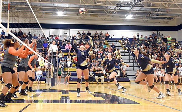 Lady Crusader Abby Shepard (center) sets the ball for her teammates Tuesday night against Waynesville at Rackers Fieldhouse. Helias won its season opener in straight sets 25-11, 25-13.