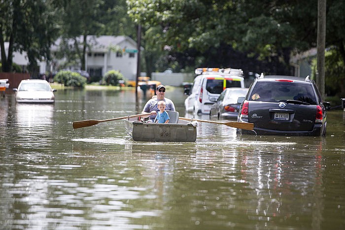 Aaron Nowak rows a boat down Danbury Drive after torrential rains flooded homes and streets Tuesday in South Bend, Indiana. 