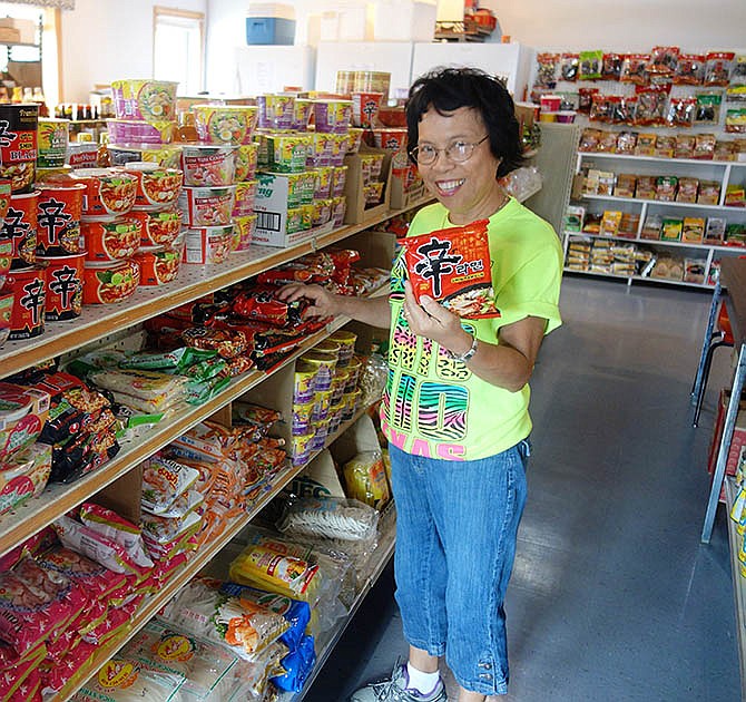 Sita Wysong, manager of Oriental Mart and Travel Services in Fulton, shows of one of the many varieties of noodles for sale in her store. "If you are talking about noodles, I have all kinds," she said. "Asian people love to eat noodles."