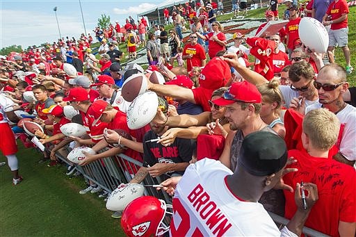 Kansas City Chiefs safety Stevie Brown, foreground, signs the shirt of a fan after a public NFL football practice Saturday July 30, 2016, in St. Joseph, Mo. (Dougal Brownlie/St. Joseph News-Press via AP)

