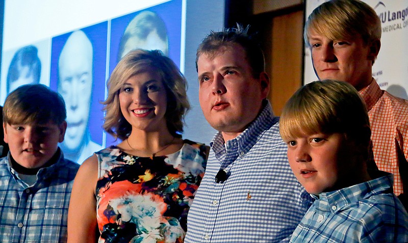 Former Mississippi firefighter Patrick Hardison, 42, center, is surrounded with his children Braden, 13, far left, Allison, 21, second from left, Cullen, 12, far right, and Dalton, 18, second from right, at a press conference marking one year after his face transplant surgery, Wednesday Aug. 24, 2016, in New York. Hardison was disfigured while trying to save people from a house fire in 2001 and received the face of a Brooklyn cyclist who died in an accident in July 2015-- a surgery successfully perform by a team of doctors at NYU Langone.