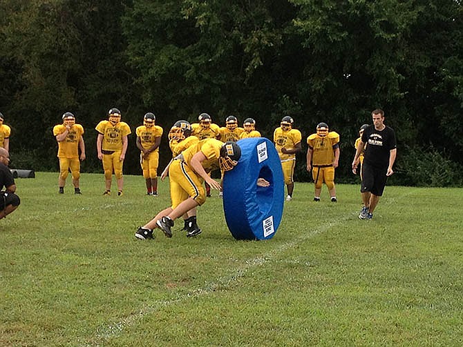 A Fulton player performs a tackle on a new tackling ring at the Hornets' practice on Tuesday. The rings were introduced at the practice.