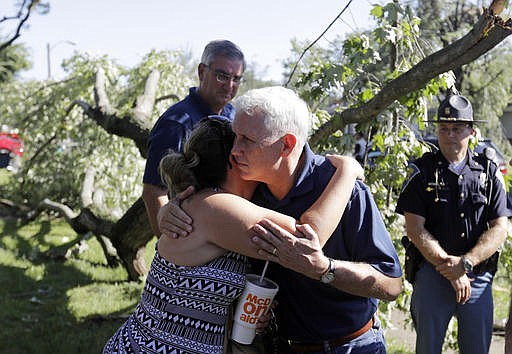 Republican vice presidential candidate, Indiana Gov. Mike Pence hugs Heidi Otiker after speaking with her, Thursday, Aug. 25, 2016, in Kokomo, Ind. Otiker's home was damaged by a tornados that passed through the area Wednesday afternoon. 