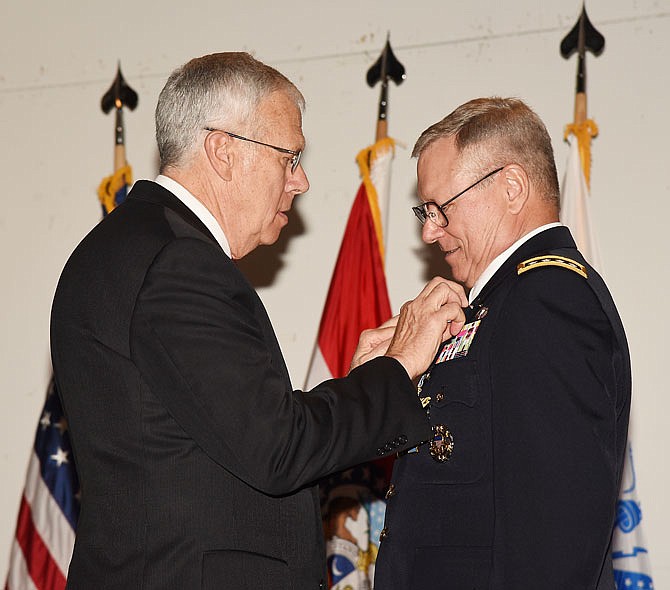 Retired Maj. Gen. Raymond (Fred) Rees, left, places the Retirement Pin on Gen. Frank Grass during a ceremony Thursday in the Capitol Rotunda. Grass was recognized by a number of current and former co-workers for his distinguished service to the Army National Guard. In a 1981 ceremony, Rees signed the papers for Grass to start his path as a general officer and was there Thursday to place the pin on his military dress uniform. 