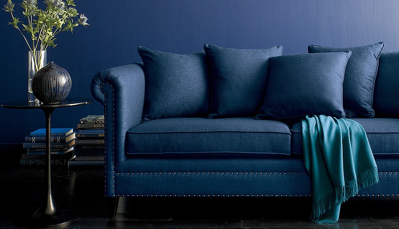 This undated photo provided by Crate & Barrel shows a blue, upholstered sofa from Crate & Barrel. Deep, rich blues are trending across all the decor categories this fall. Furniture like this sofa in a warm navy hue bring coziness home for the cooler months. 