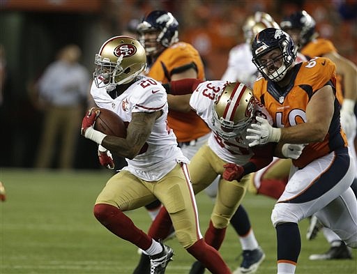San Francisco 49ers cornerback Kenneth Acker, left, runs the ball after an interception in the second half of a preseason NFL football game against the Denver Broncos, Saturday, Aug. 20, 2016, in Denver.