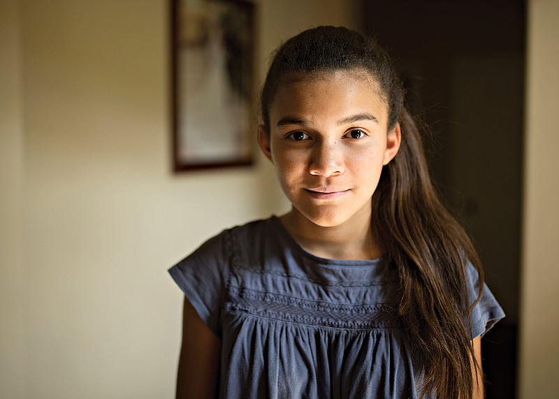 This photo taken July 20, 2016, shows Gloria Fortner, 13, posing for a portrait at the the family home in Lancaster, Texas. Fortner is biracial, her father is African American and her mother is originally from Mexico.