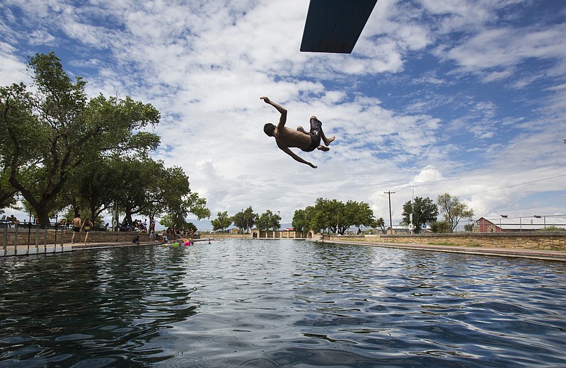 In this Aug. 18, 2016 photo, a boy jumps off the diving board into 30 feet of water at the natural spring pool at the Balmoreah State Park in Balmoreah, Texas. The rise of fracking nearby the town has some community members worried about their drinking water and natural springs, which serve as a popular tourism destination helping drive the town's economy.