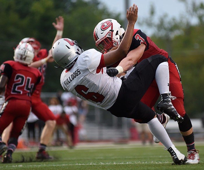 Jefferson City linebacker Gaven Strobel puts a hard hit on Springfield Central quarterback Danny Adams while members of the Jays' secondary look to intercept the errant pass Friday, Aug. 26, 2016 during their game at Adkins Stadium