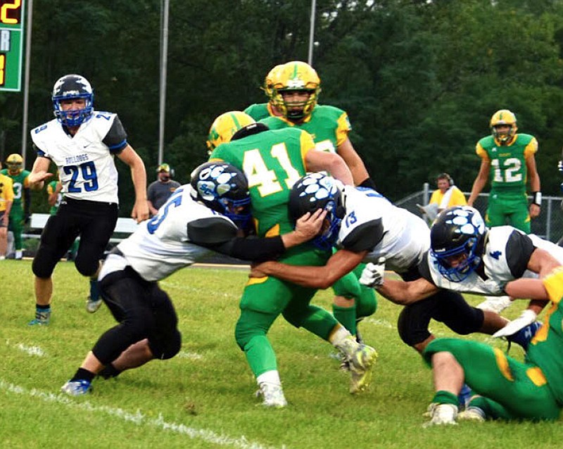 South Callaway sophomore free safety Peyton Leeper (left) and junior linebacker Landon Horstman team up to take down Milan senior running back Jaidyn Watts (41) during the Bulldogs' 39-0 rout of the Wildcats on Friday night in Milan. (Shelly Sconce/Contributed)