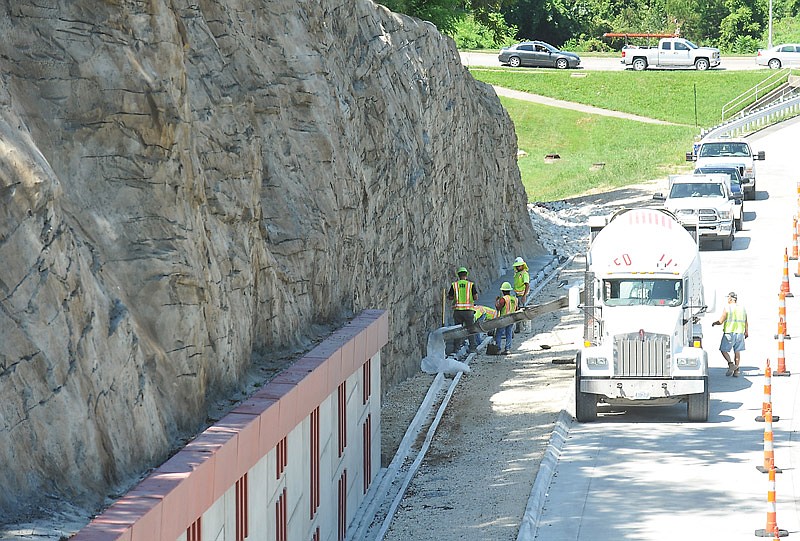 Concrete is poured along the base of the faux rock bluff near the Jackson Street overpass. Emery Sapp and Sons has been setting concrete pylons, which will support lights at the four corners of the overpass.