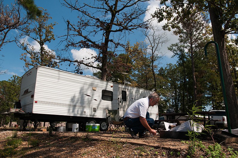  Tarnley Tarhan from Sulphur, La., works on making a campfire while camping Friday at Millwood State Park. The park has received serious renovations since damages from flooding last year.