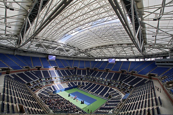 In this Aug. 2 file photo, the partially open new retractable roof allows a ribbon of light into Arthur Ashe Stadium at the Billie Jean King National Tennis Center in New York. With the stadium now covered by a retractable roof, players such as Novak Djokovic wonder how it will affect conditions when it is closed during the U.S. Open.