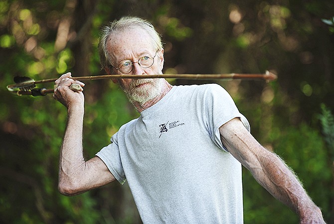 Jerry Nevins demonstrates a throwing stance using an atlatl.