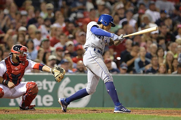 Royals second baseman Raul Mondesi hits a three-run triple as Red Sox catcher Sandy Leon looks on during the sixth inning of Sunday night's game at Fenway Park in Boston.
