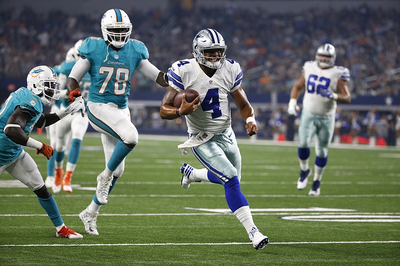 Miami Dolphins' Terrence Fede gives chase as Dallas Cowboys quarterback Dak Prescott heads to the end zone for a touchdown during the first half Friday in Arlington, Texas. After Tony Romo broke a bone in his back on the third play of the third preseason game at Seattle, Jerry Jones is ready to roll with Prescott as the starting quarterback. 